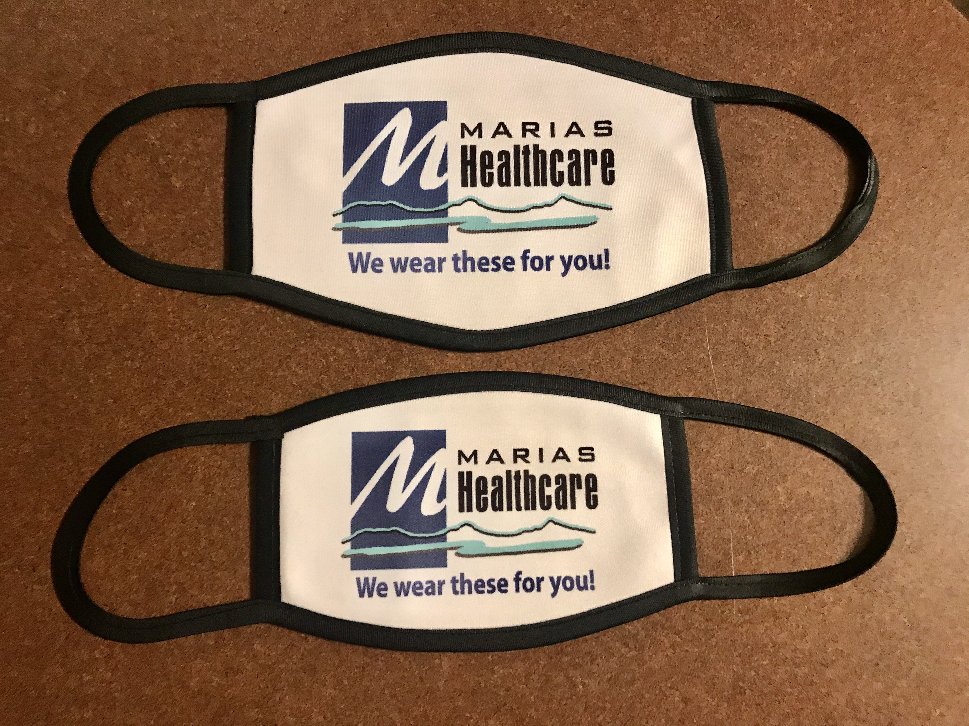 Small and large face masks with a local medical facility logo for staff to wear in the office t