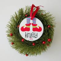 Personalized ornament sitting on top of a sparkly wreath.