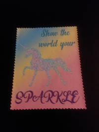 Microfiber lens cloth with a multicolor background and a unicorn design with the quote 