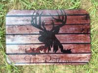 Small glass cutting board with a deer head overlayed on wood